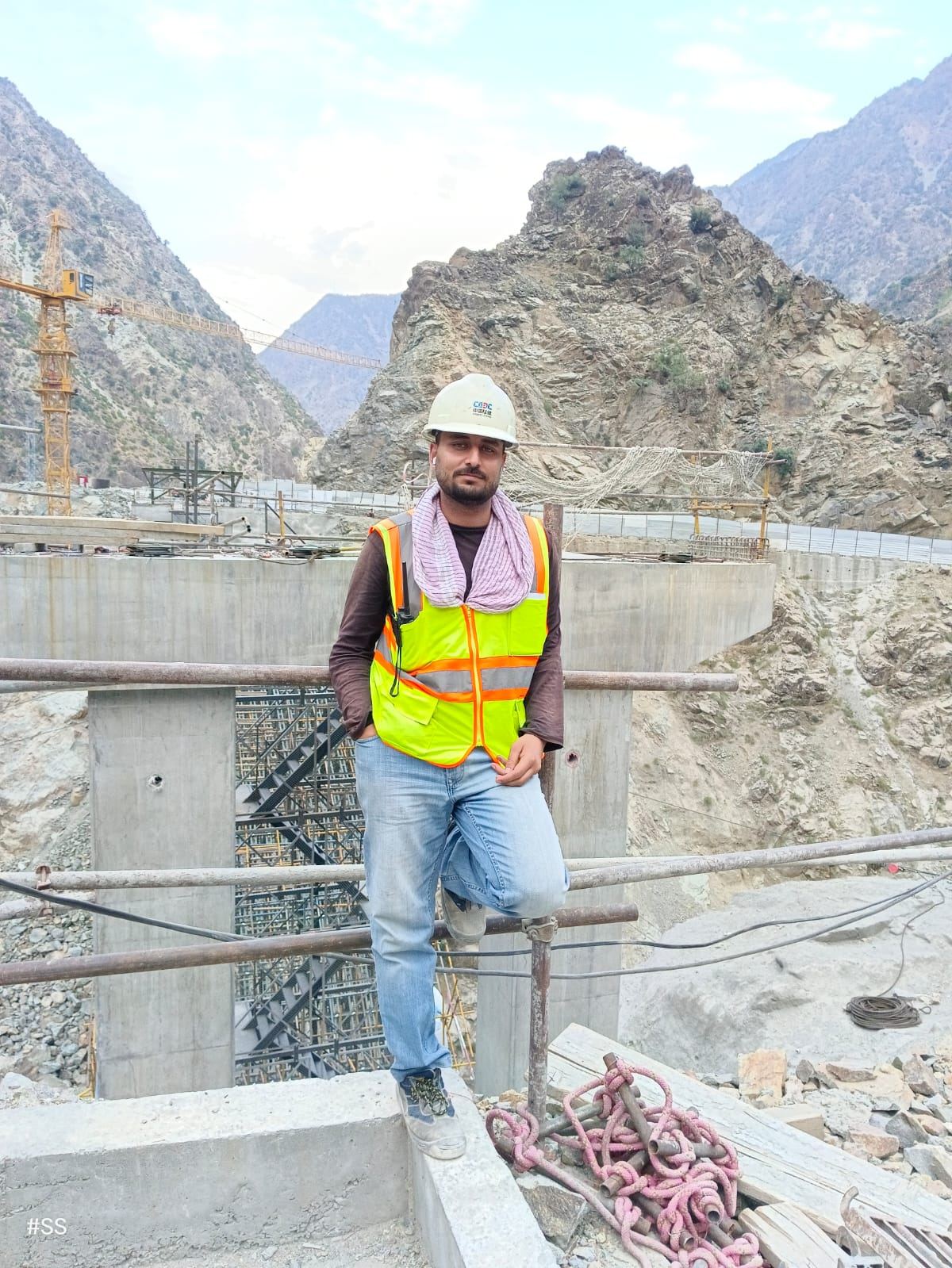 Suleman Hakeem beside the abutment pier, cranes in background